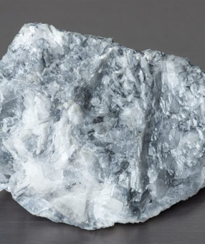 Specimen of mineral magnesite on gray background